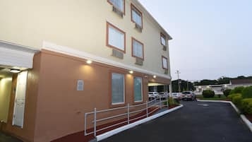 A two-story building with a parking lot and a gated entrance.
