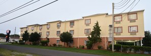 Ein mehrstöckiges Hotel mit einer beige gefärbten Fassade, zahlreichen Fenstern und einem überdachten Eingang.