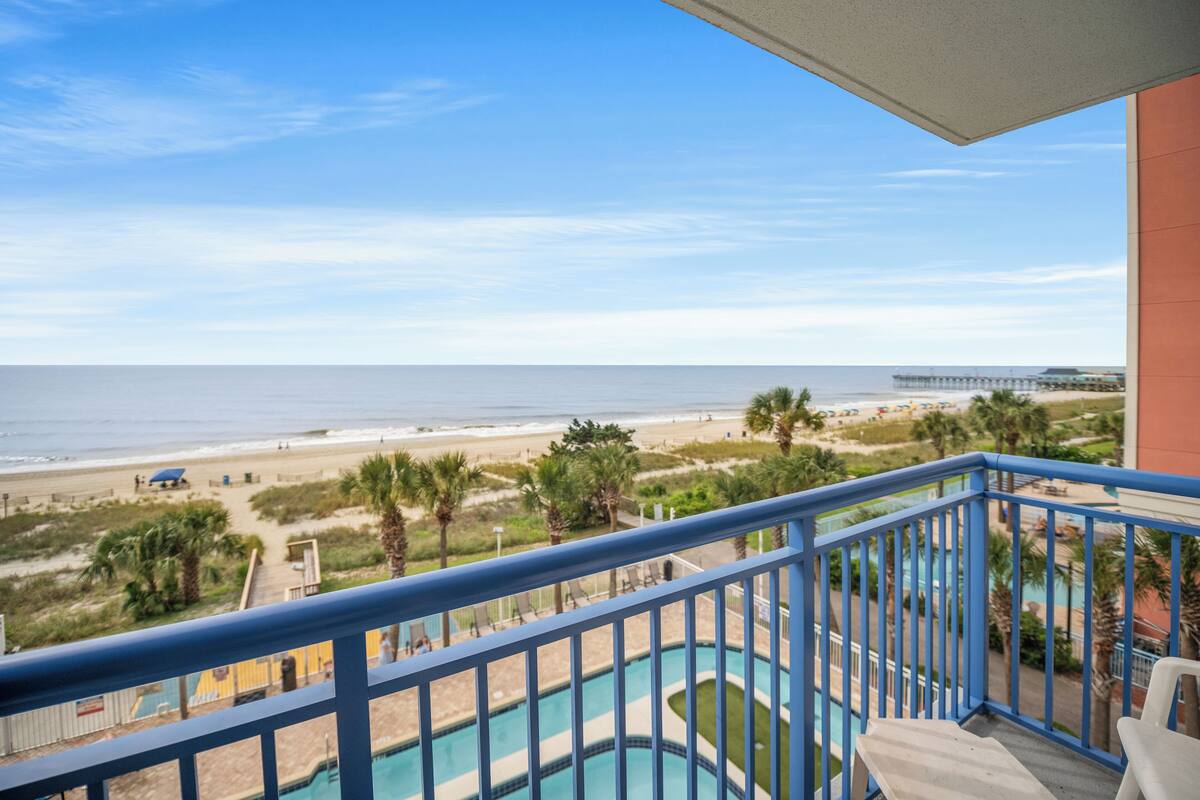 Ein Balkon mit Blick auf Strand und Meer.