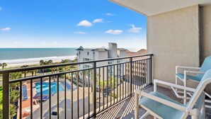 A balcony with a view of the ocean and a pool area. - Units at Ocean Forest Plaza by Elliott Beach Rentals (Myrtle Beach)