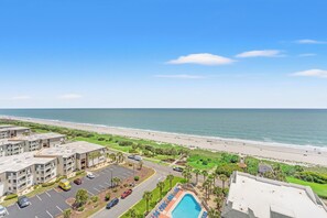 Un hôtel de grande hauteur doté d’une piscine, offrant une vue sur la plage et disposant d’un parking.