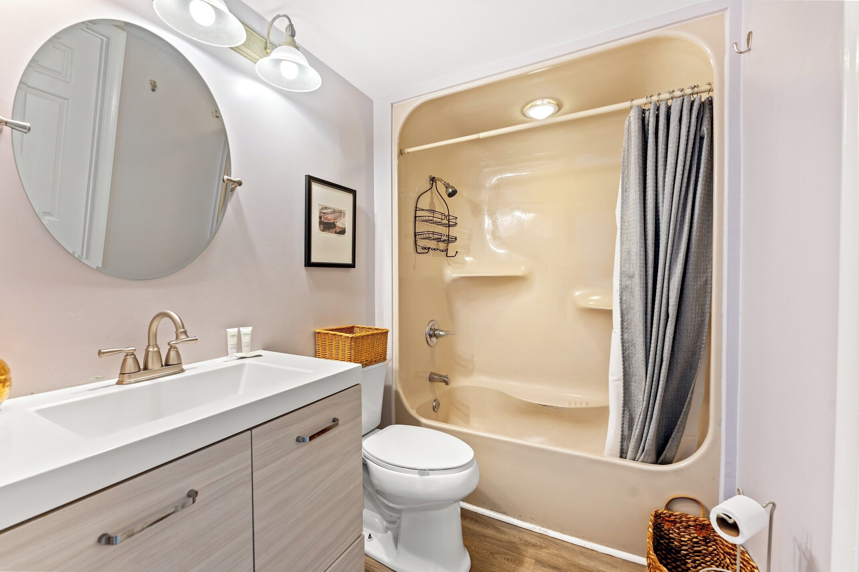 Un baño con lavamanos blanco, inodoro, bañera y espejo.