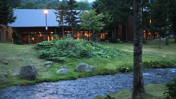 Surrounded by lush greenery and a serene stream, this riverside retreat offers a tranquil escape.