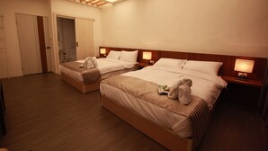 Habitación de hotel con dos camas, cabeceros de madera, lámparas de noche y un tragaluz.