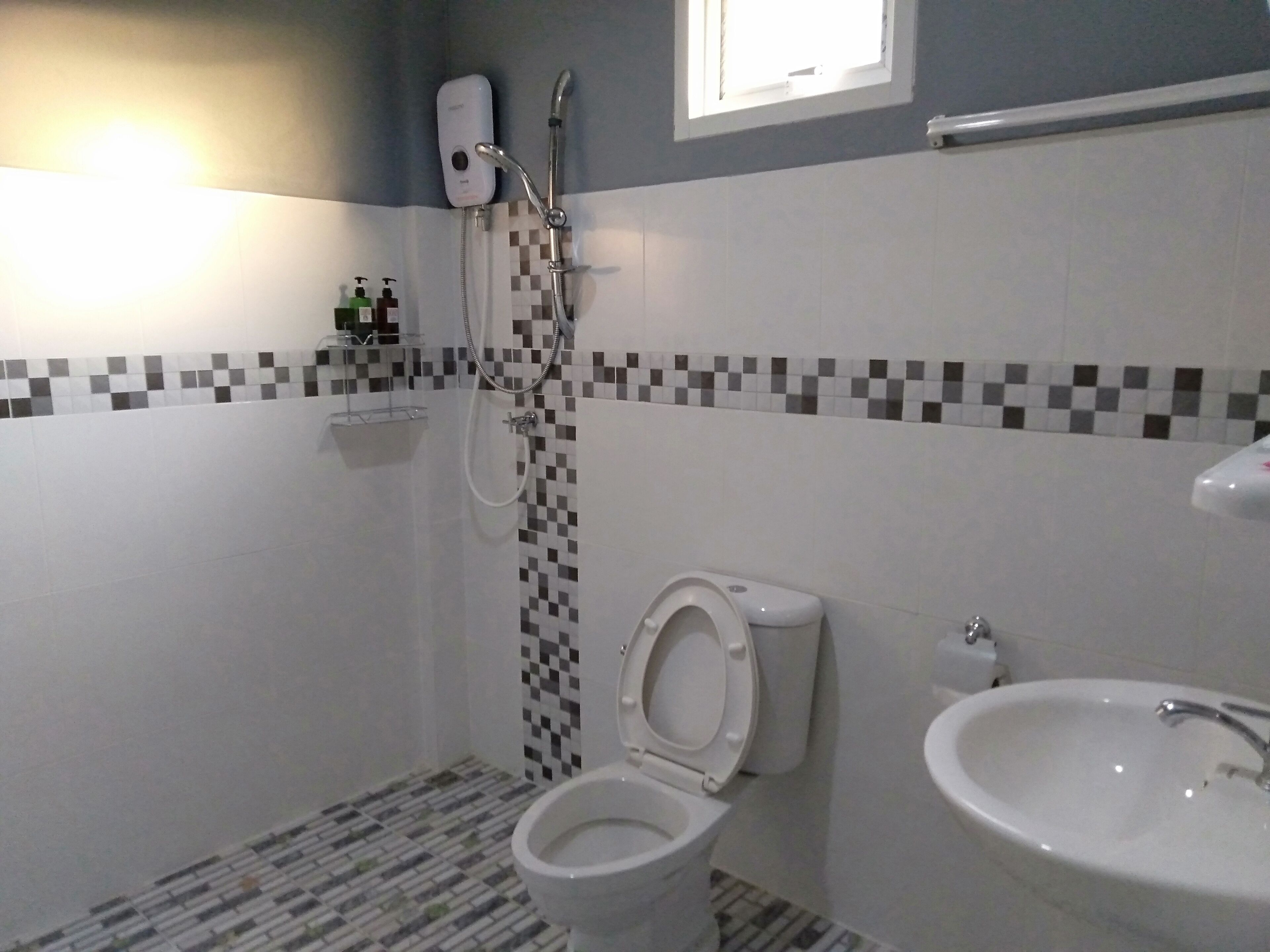 Une salle de bain équipée de toilettes, d’un bidet et d’un lavabo.