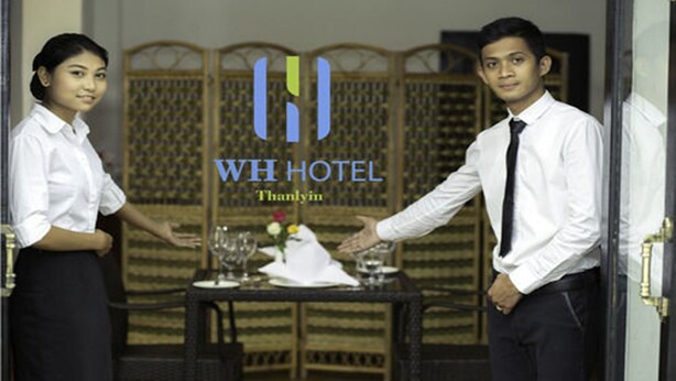 Ein Schild mit dem WH HOTEL-Logo und -Namen.