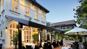 Een gebouw met een overdekt terras, grote ramen en een goed verlichte ingang.