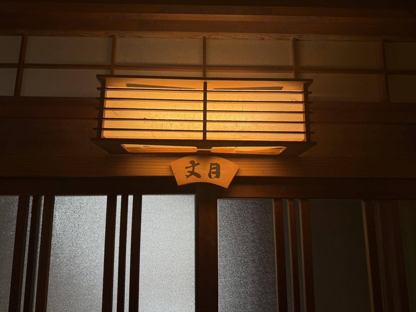 Een traditionele Japanse kamer met tatami vloerbedekking, een shoji schuifwand en een hangende shimenawa.