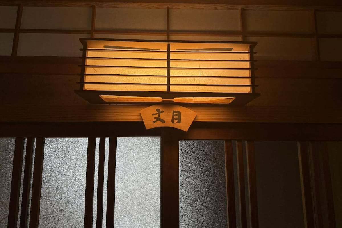 Une pièce de style japonais traditionnel, avec un sol recouvert de tatamis, un paravent shoji et un shimenawa suspendu.