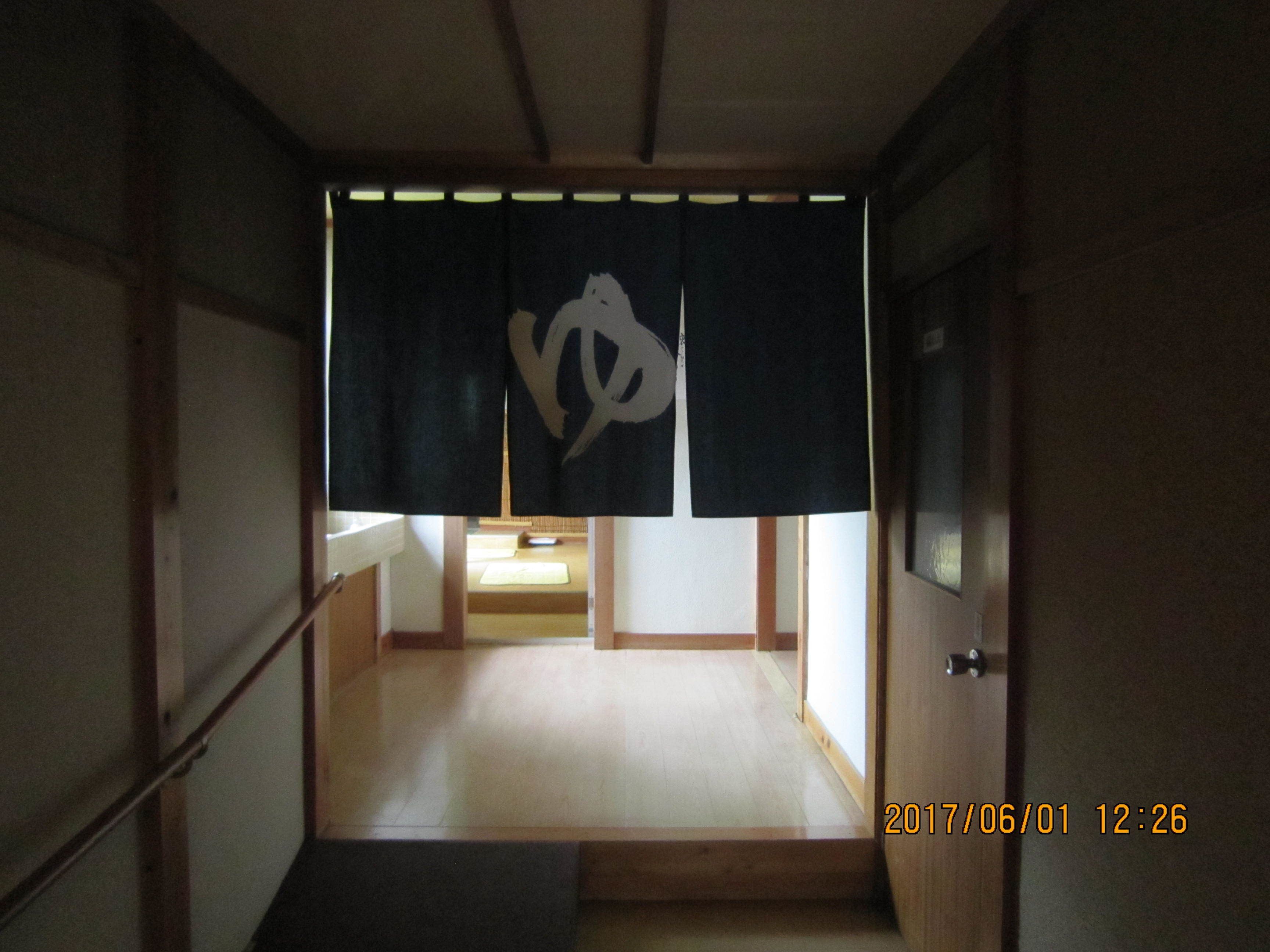 A traditional Japanese room with tatami flooring, a shoji screen, and a low wooden desk.