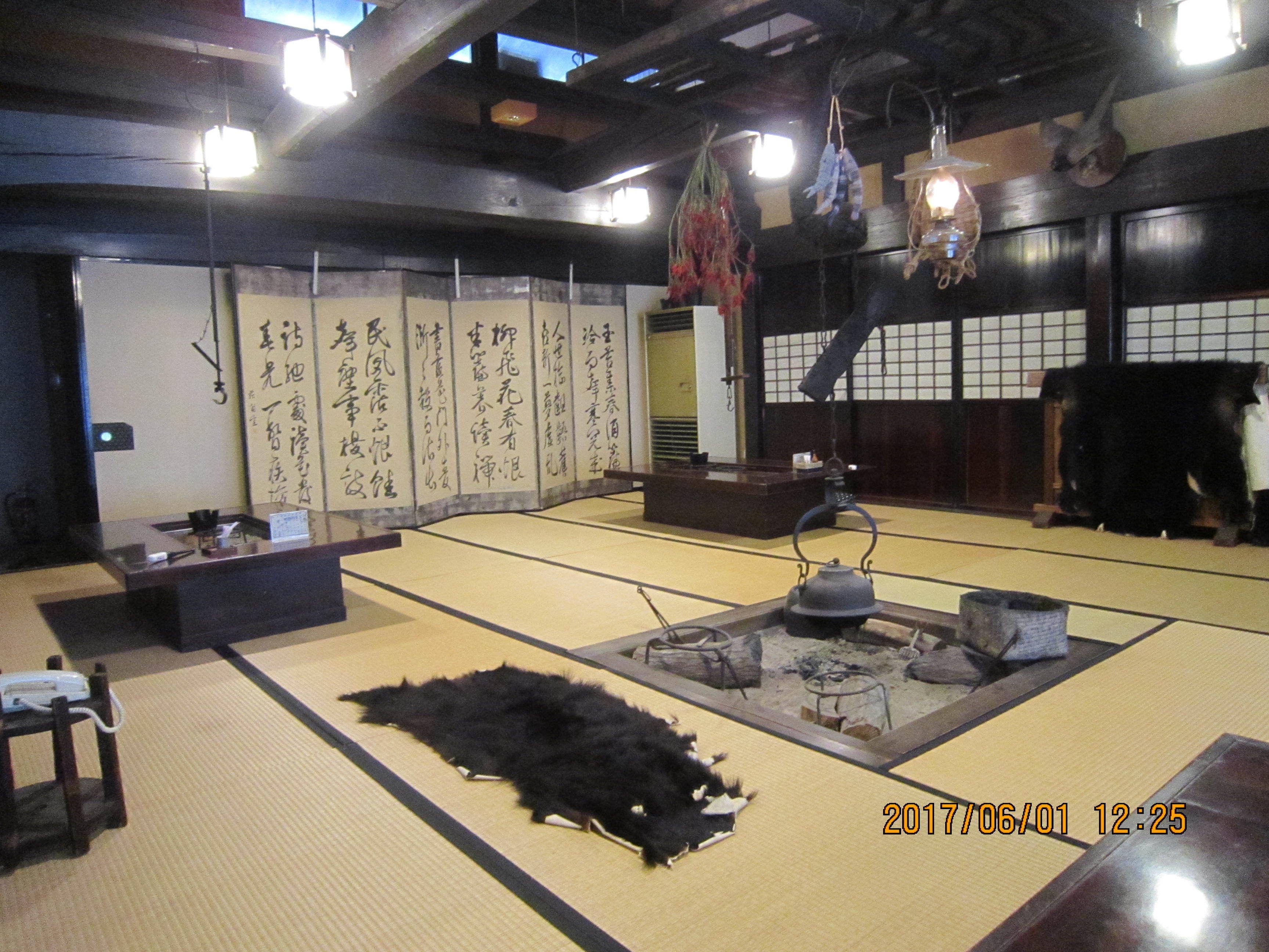 Una habitación tradicional con esteras de tatami y una disposición para ceremonia del té, incluyendo una tetera y un recipiente para té.