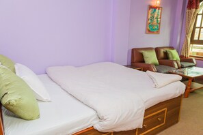 A bedroom with a bed, a sofa, and a small table. - Swastik Guest House (Bhaktapur)