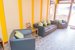 A reception area with a sofa, chairs, and a small table. - Swastik Guest House (Bhaktapur)
