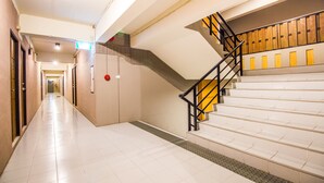 A corridor with a staircase leading to a landing with wooden panels. - B2 Santitham (Wat Jed Yod) Boutique & Budget Hotel (Chiang Mai)