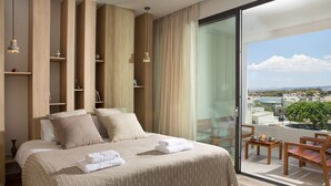 Habitació d'hotel moderna amb un llit gran, revestiment de fusta, un balcó amb seients i vista a la ciutat.