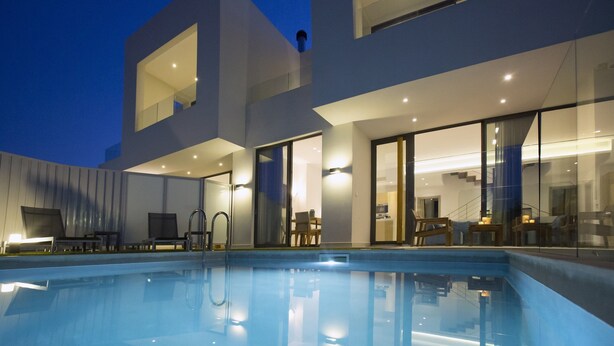 Zona de piscina moderna amb una piscina nítida, arquitectura contemporània i un espai interior ben il·luminat.