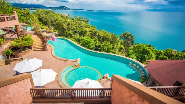A resort with a large infinity pool, outdoor seating, and a view of the ocean. - Samui Bayview Resort & Spa (Koh Samui)