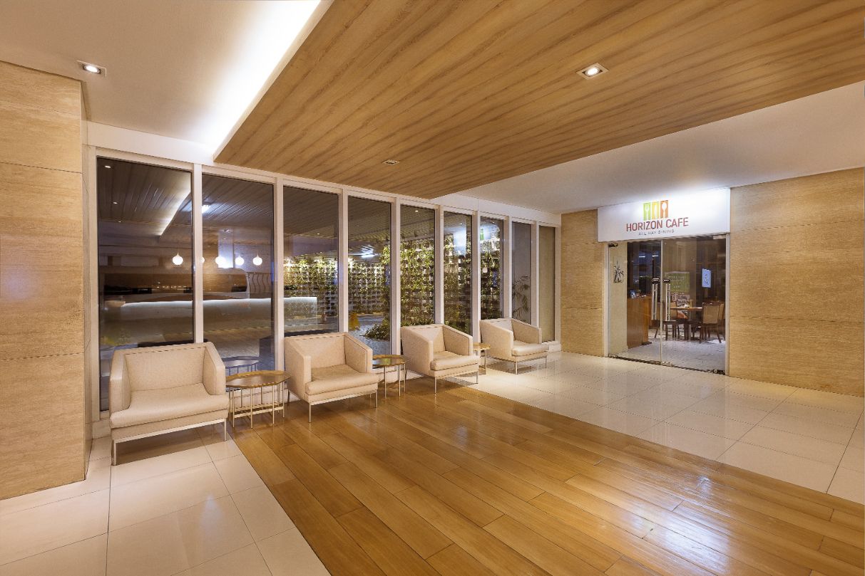 Un intérieur moderne comprenant un espace d’accueil, un plancher en bois et une enseigne « Horizon Cafe ».