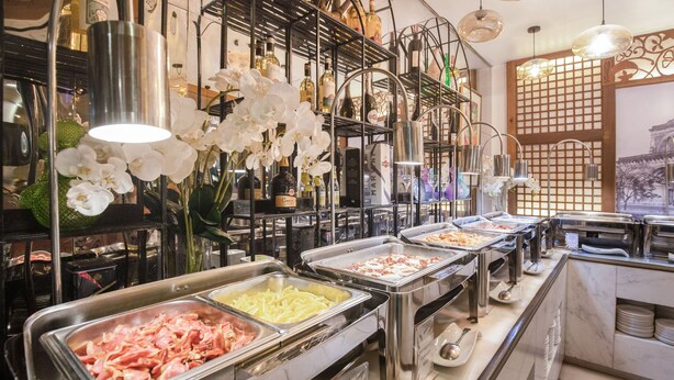 Zona de bufé con diversas opciones de comida, incluyendo papas fritas, y una selección de bebidas alcohólicas.