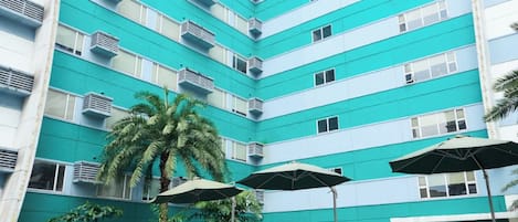 Piscina com uma pessoa segurando outra acima da água.