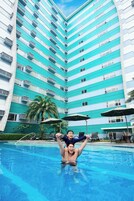 A swimming pool with a person holding another person above the water.