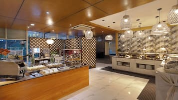 A hotel lobby with a buffet area, a reception desk, and a patterned wall.