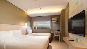 Habitación de hotel con dos camas, un escritorio, una silla, un televisor y vistas a la ciudad.
