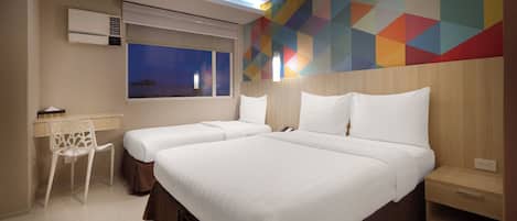 A hotel room with two beds, a desk, and a chair.