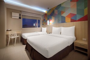 Una habitación de hotel con dos camas, un escritorio y una silla.