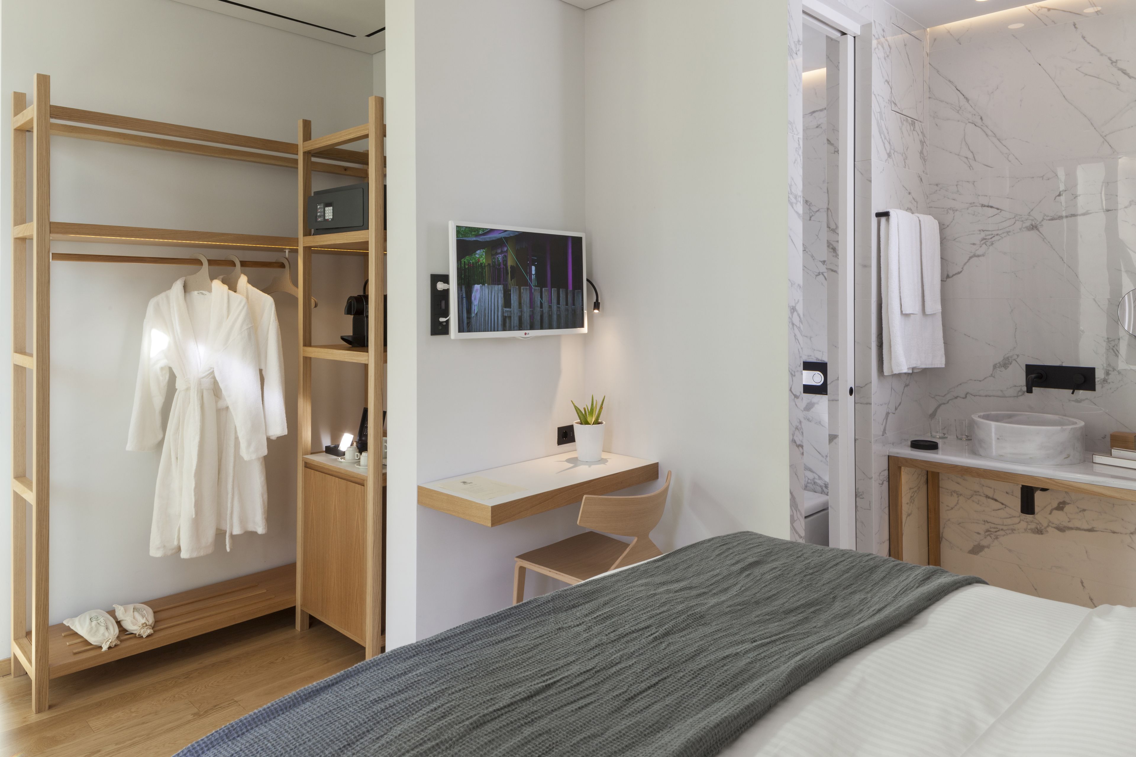 Un dormitorio moderno con cama, escritorio y armario.