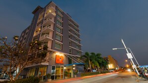 Um hotel com vários andares, um destaque para a placa 'B2', varandas e uma entrada bem iluminada.