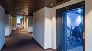 A hallway with a view of a city street through a glass door.