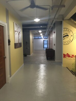 A hallway with a ceiling fan, a light fixture, and a wall with a circular emblem.