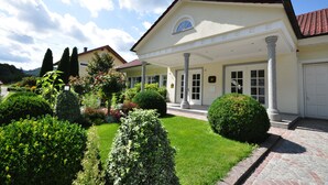 A two-story building with a white facade, a red-tiled roof, and a covered entrance with columns. - Baumanns Landhaus Durbach (Durbach)