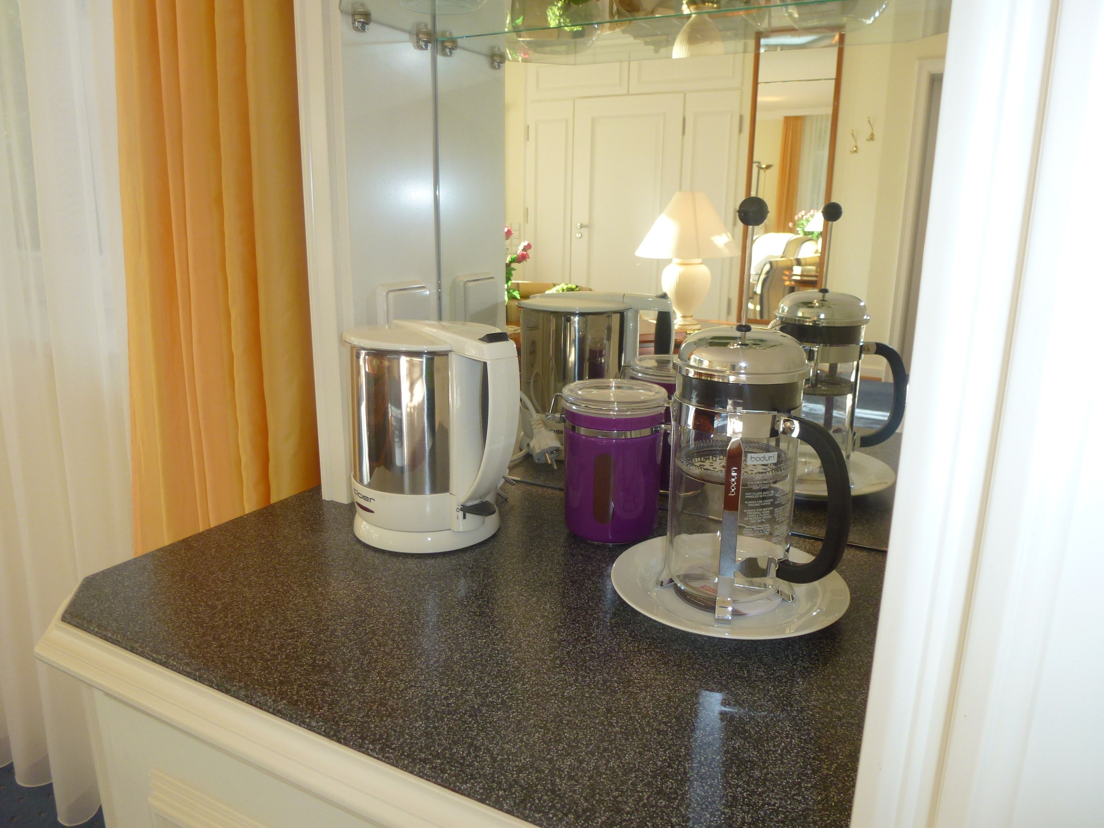 A kitchen counter with a coffee maker, a blender, and a pot.