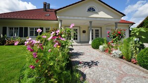 A two-story house with a red-tiled roof, a central entrance with a white door, and a small balcony. - Baumanns Landhaus Durbach (Durbach)