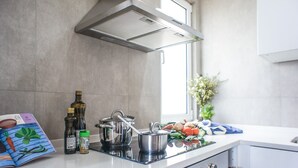 Una cocina moderna con electrodomésticos de acero inoxidable, horno integrado y ventana que proporciona luz natural.