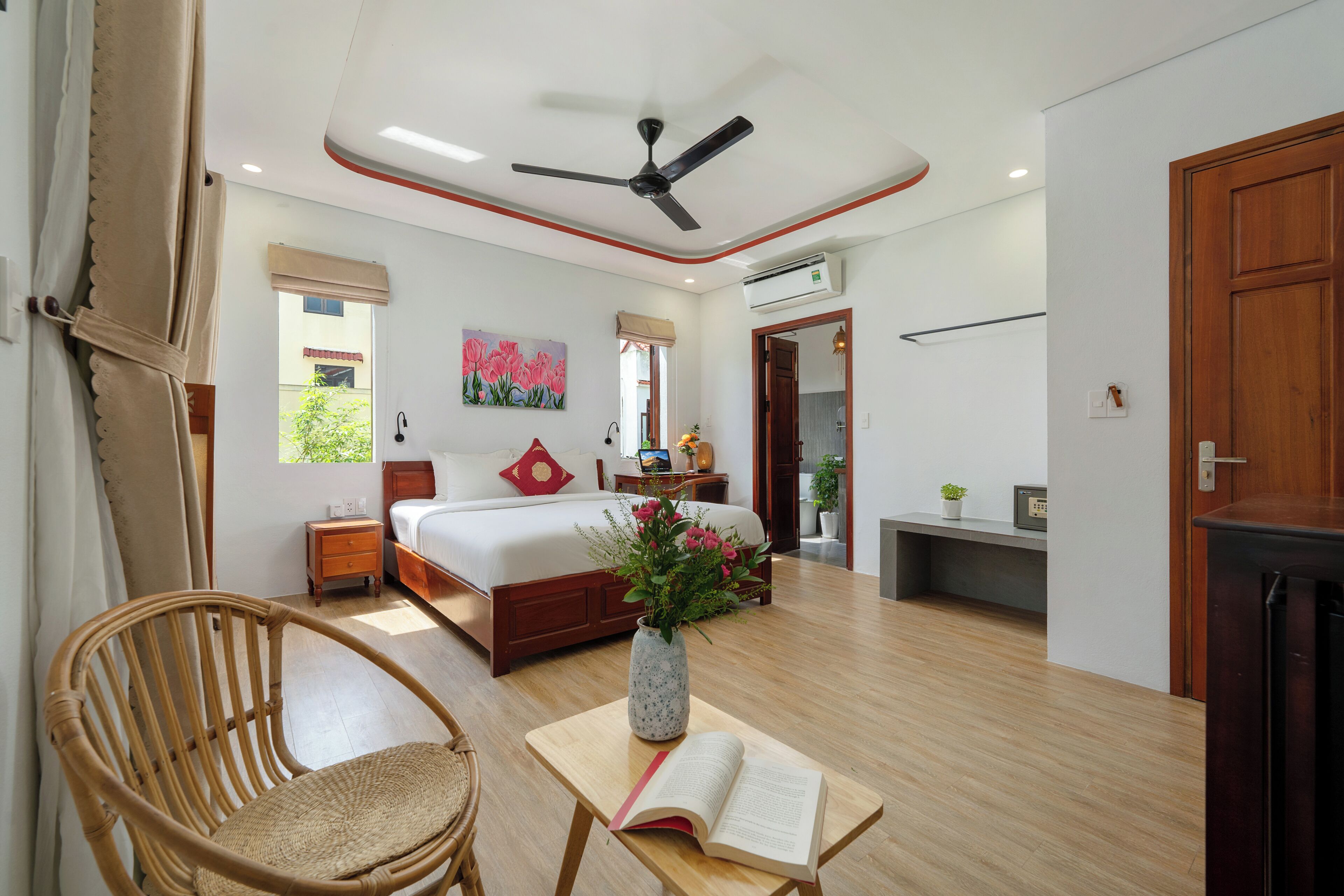 A well-lit bedroom with a bed, bedside table, and a chair.