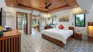 A bedroom with a large bed, wooden ceiling, patterned floor, and a desk with a mirror. - Red Flower Cottages Homestay (Da Nang)