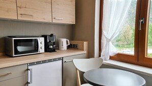 A compact kitchenette with a microwave, coffee maker, and a small refrigerator. - Hotel Kachelburg (Dieblich)