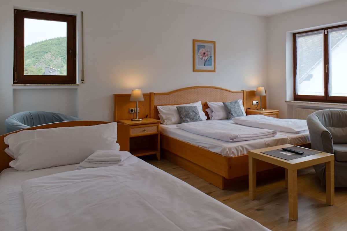 Een hotelkamer met twee enkele bedden, een bank, een stoel, een kleine tafel en twee bedlampjes.