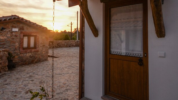 A rustic building with a wooden door and a small porch.