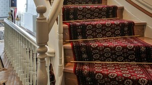 A grand staircase with ornate balusters and carpeted steps. - 1905 Boutique Hotel (Xanthi)