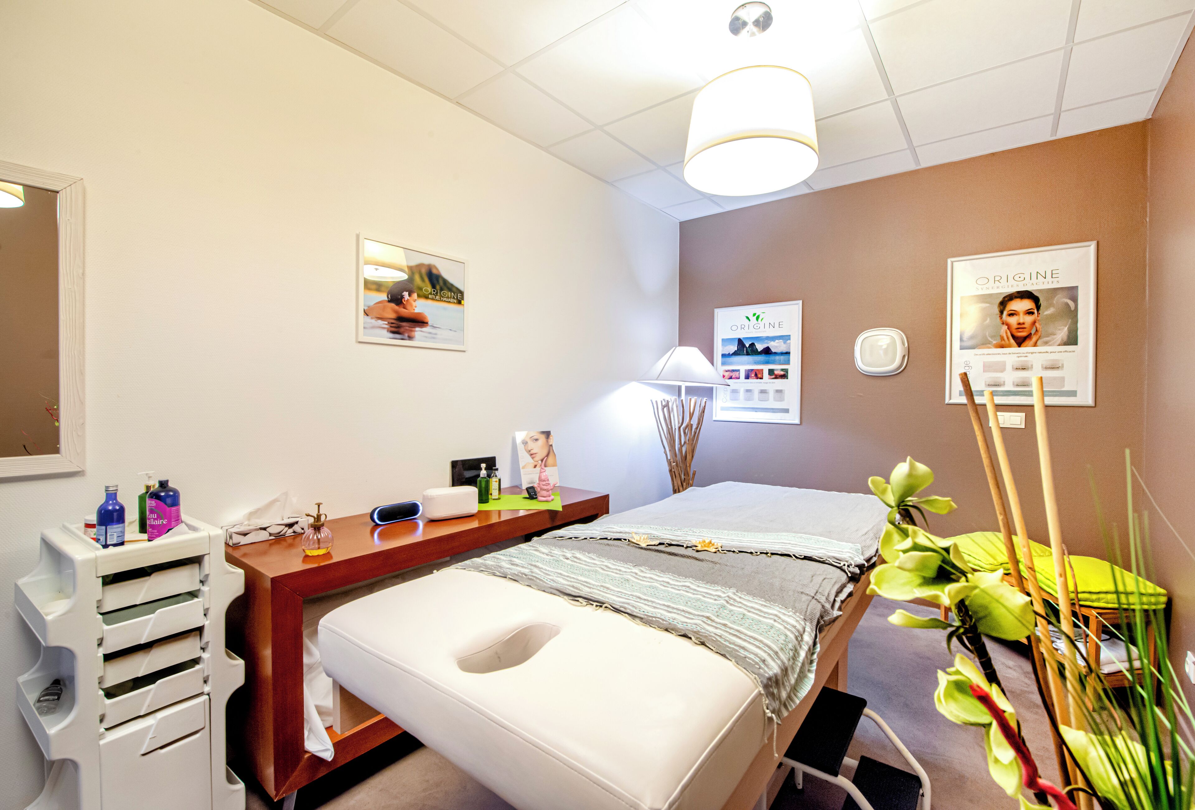 Une pièce bien rangée, avec un lit, une table de chevet et un petit bureau avec une chaise.