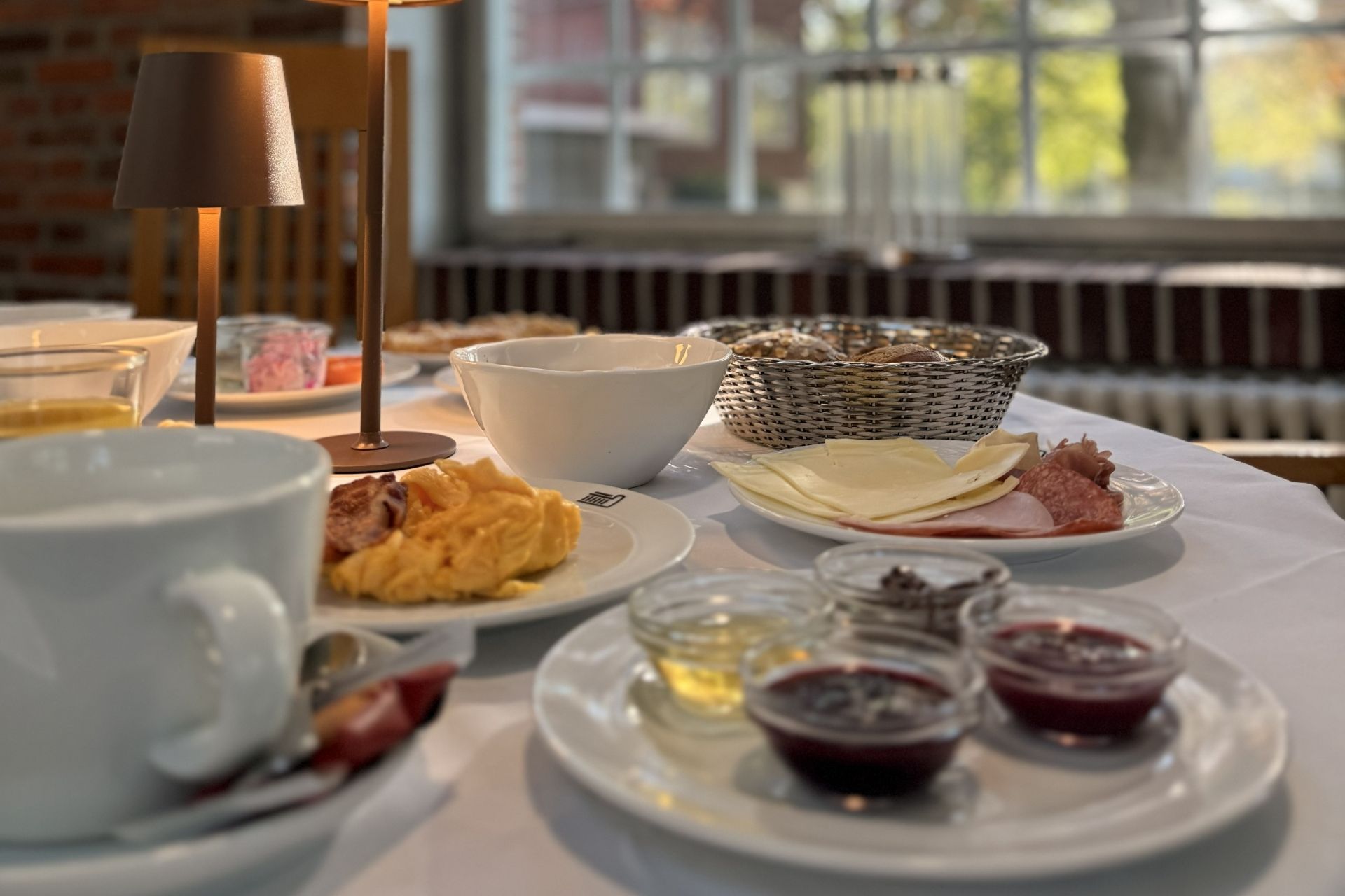 Un bufé de desayuno con diversos alimentos y una vela sobre una mesa.