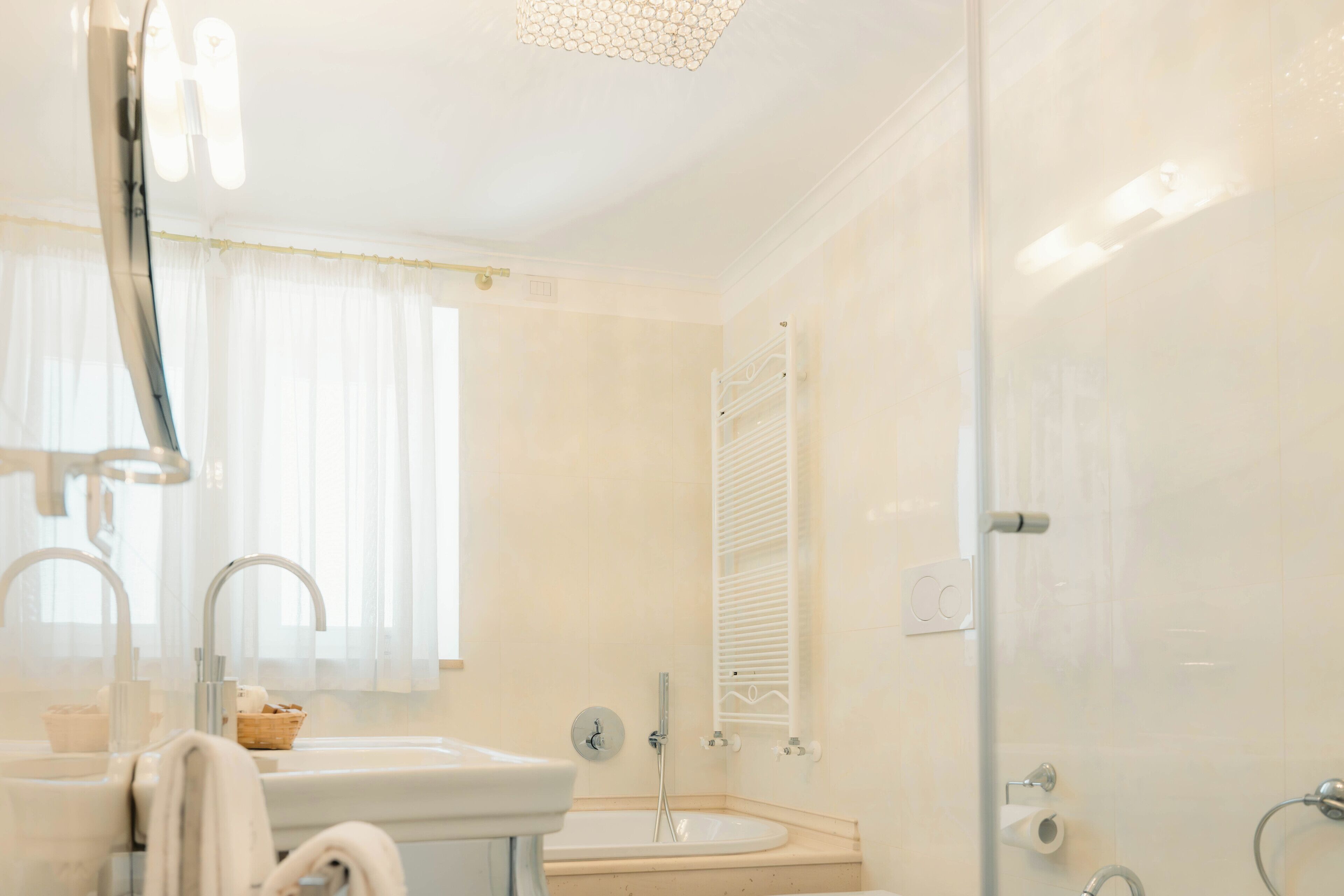 Een badkamer met een wastafel, spiegel en douche.