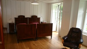 Une chambre à coucher avec un lit en bois, un fauteuil à bascule et une table de chevet.