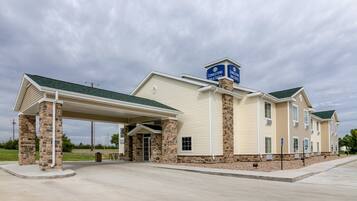 Hotel features a covered outdoor area with a roof supported by pillars, offering a comfortable space to relax.
