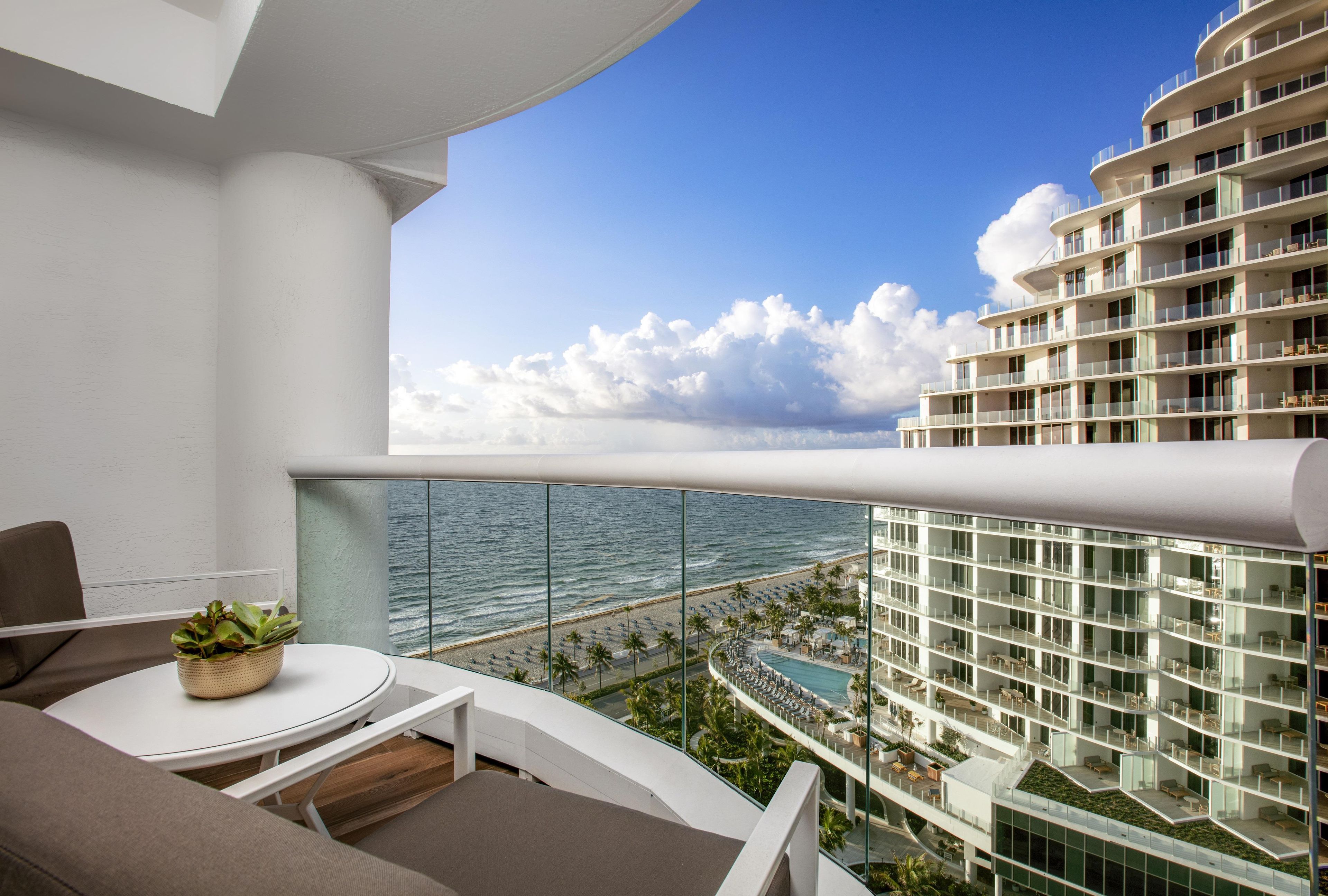 Un balcón con vista al océano y un edificio de resort.