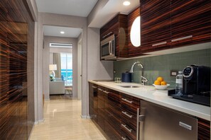 A modern kitchen with a built-in microwave, stainless steel appliances, and a view to the outside. - Conrad Fort Lauderdale Beach (Fort Lauderdale)